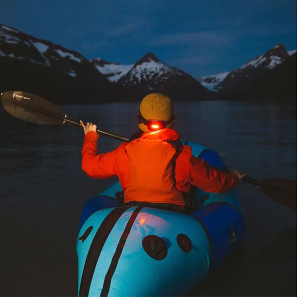 Lifestylebild von einem Mann auf einem Kanu mit einer Stirnlampe von BioLite