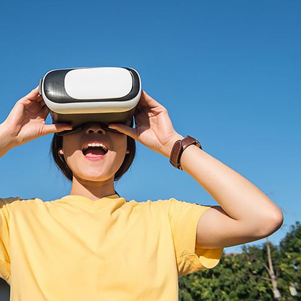 Mädchen mit VR Brille schaut in den Himmel