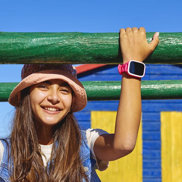 Mädchen mit Xplora Smartwatch haltet sich mit einer Hand an einem Holzbalken fest