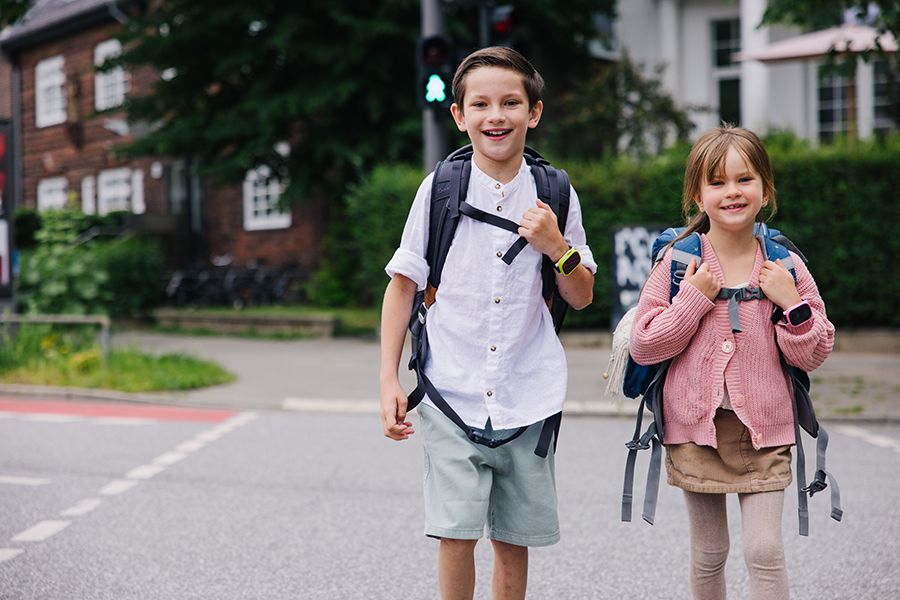 Zwei Schulkinder überqueren die Strasse mit Xplora Smartwatches