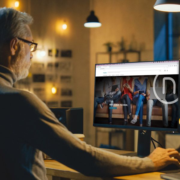 Ein älterer Mann sitzt vor dem Computer und schaut sich die novis Homepage an