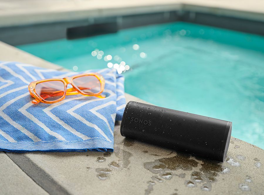 Eine Schwarze Sonos Roam 2 am Pool neben einer Sonnenbrille
